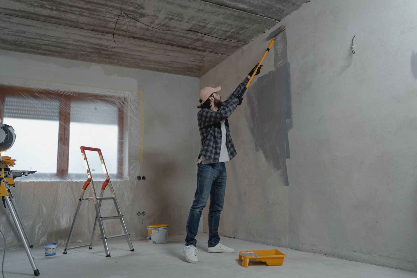 A painter rolling fresh paint onto an interior wall